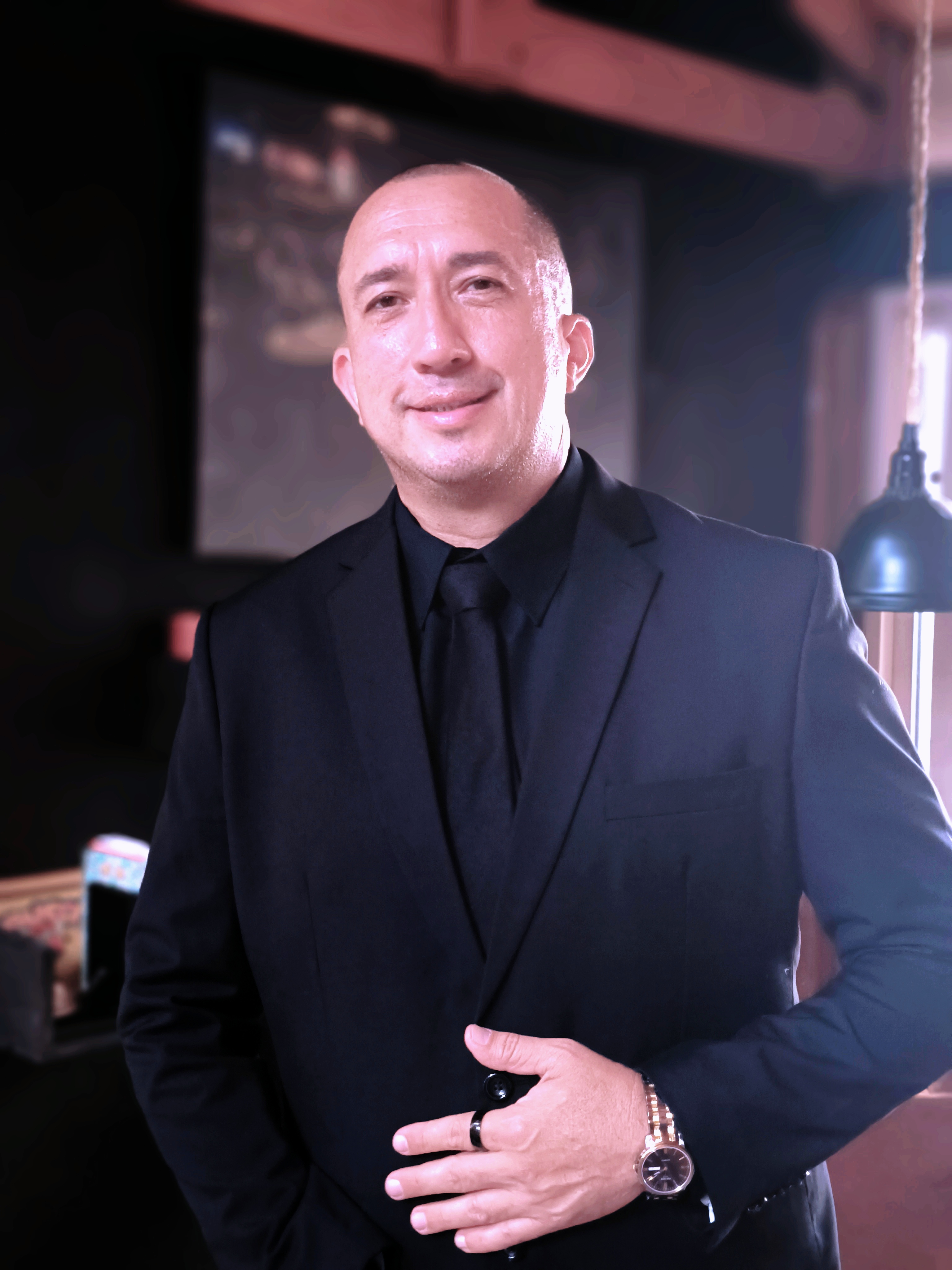 Allan Rivera de pie en traje formal